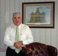 Dan Frizzi standing in front of a painting of the courthouse